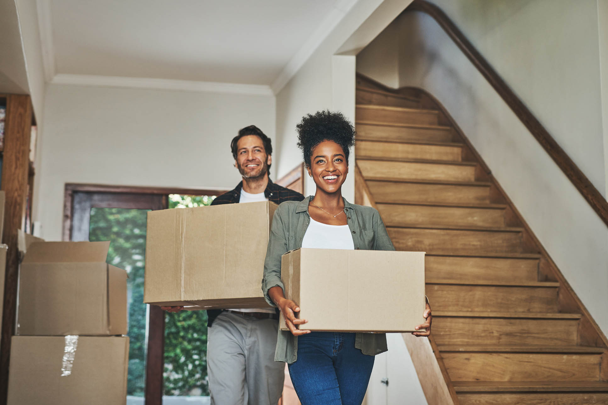 Happy couple, real estate and moving in new home with boxes for renovation, investment or relocation. Interracial man and woman owner carrying box for property rent, mortgage loan or move together Städföretag i Vara som städar badrum - Grundlig städning